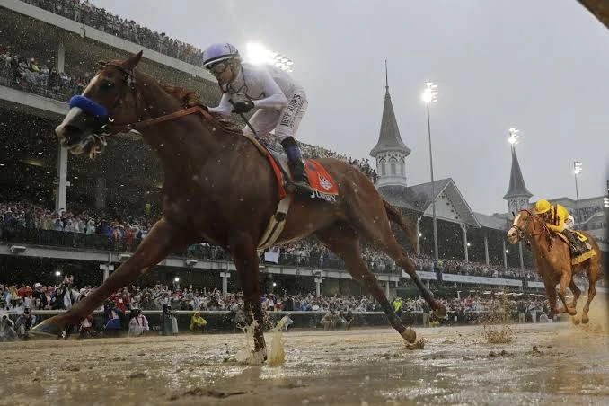 Racehorses splash through a muddy Churchill Downs track during the Kentucky Derby.